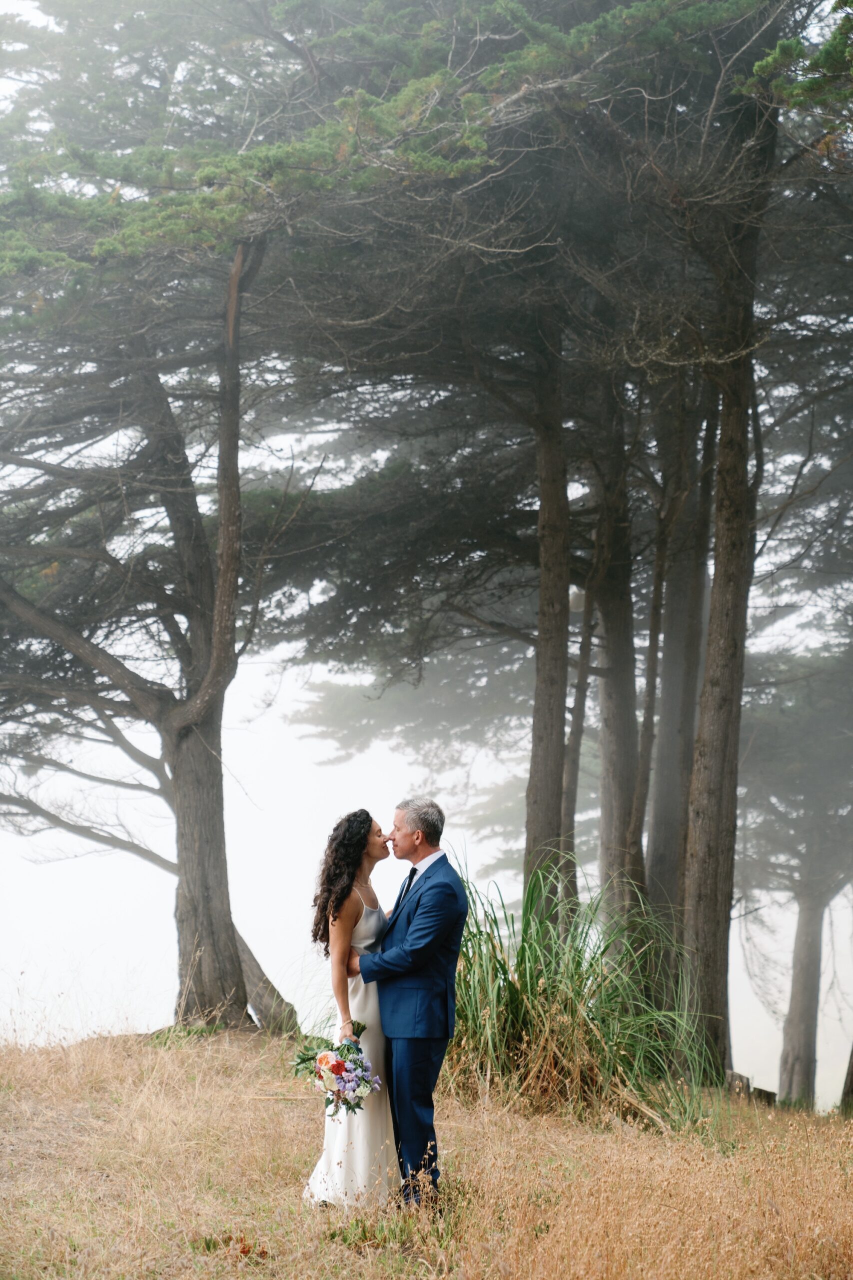 wedding portraits on the cliffs of Aptos Beach with cypress trees