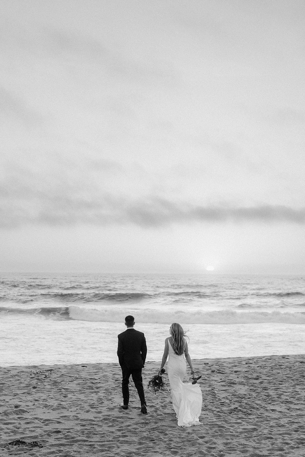 black and white wedding couple near ocean