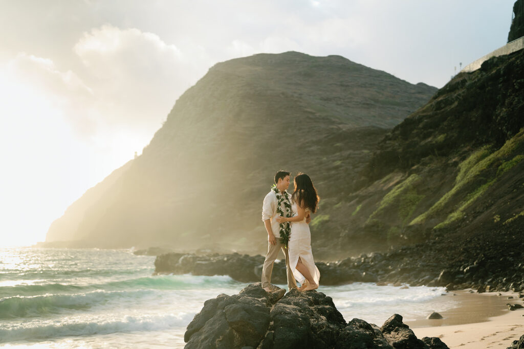 couple on rocks at sunrise for a hawaii elopement