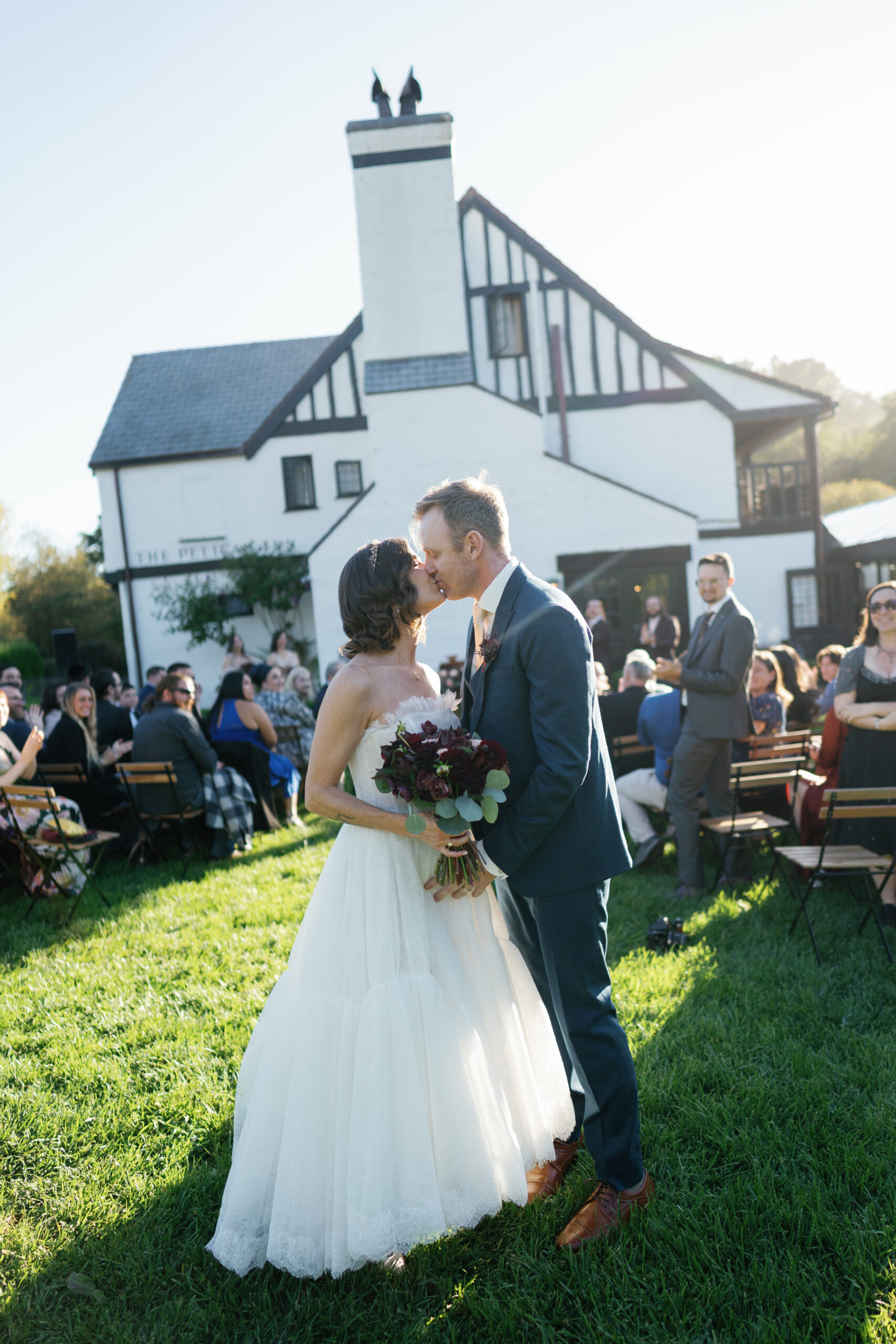 Couple kissing at their wedding the end of the aisle at Pelican Inn